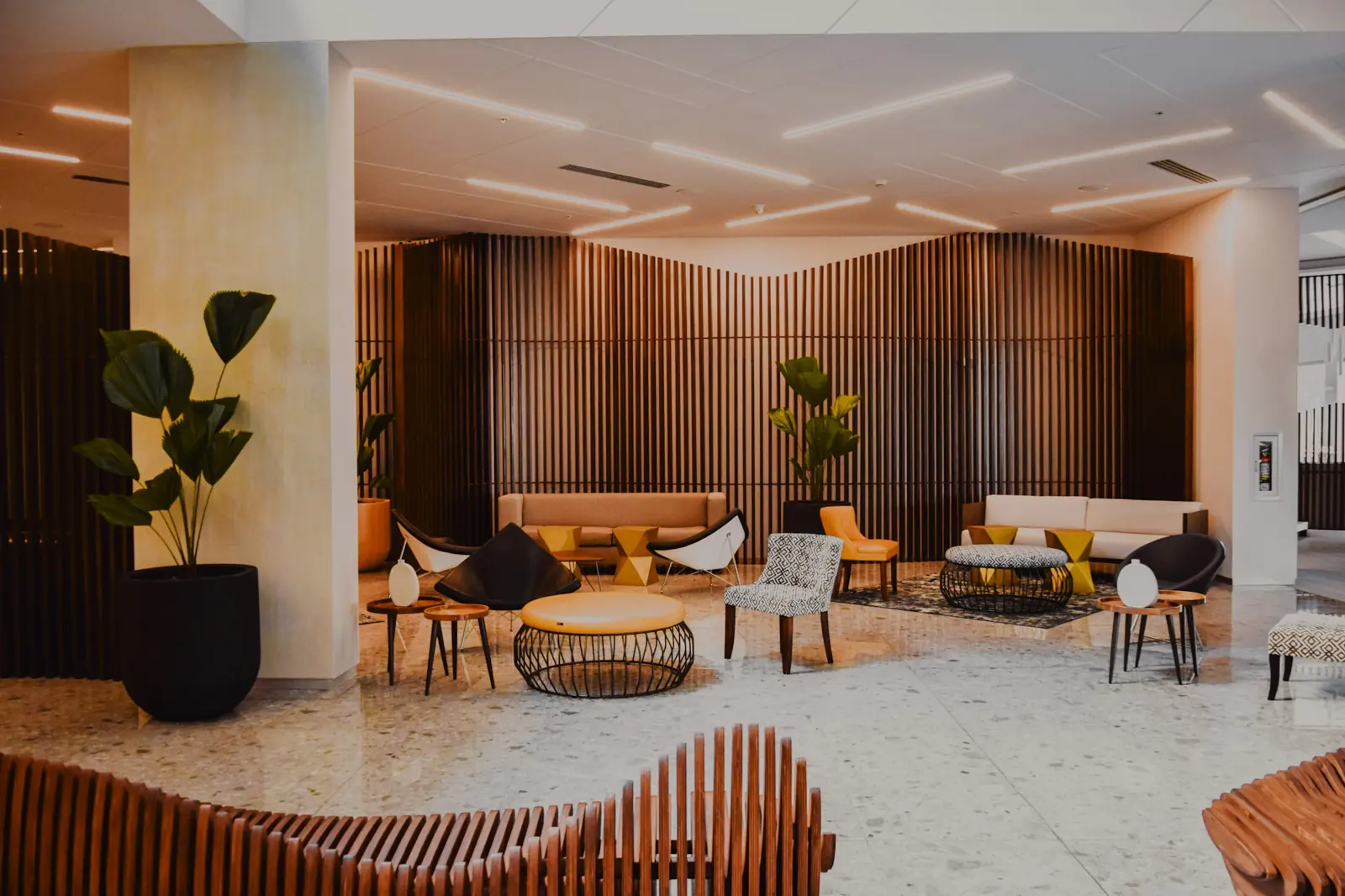 A bright, modern hotel lobby with wood walls and lounge seating